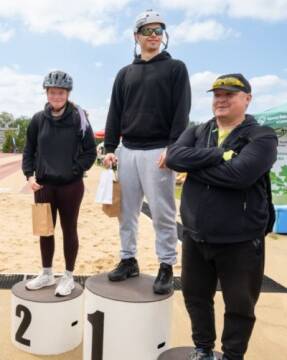 Zwycięzcy na podium Trzy osoby na podium, pierwsze miejsce w środku